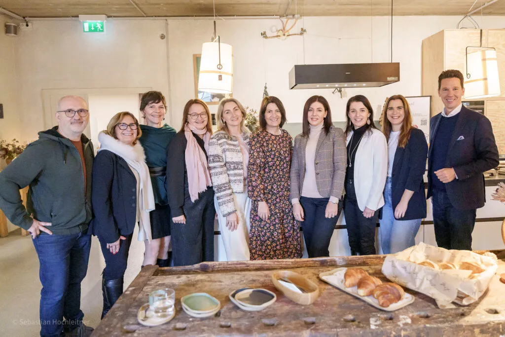 Gruppe von Teilnehmenden beim HR Role Model Brunch in modernem Loft mit gedecktem Tisch und Gebäck