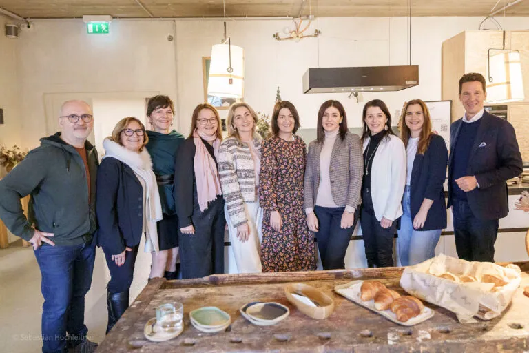 Gruppe von Teilnehmenden beim HR Role Model Brunch in modernem Loft mit gedecktem Tisch und Gebäck